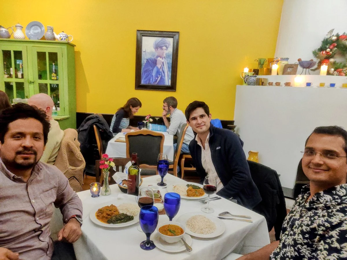 Dr. Omar Costilla Reyes and other workshop attendees gathered around a dinner table after the first day of the MIT AI for Code and Science Workshop.