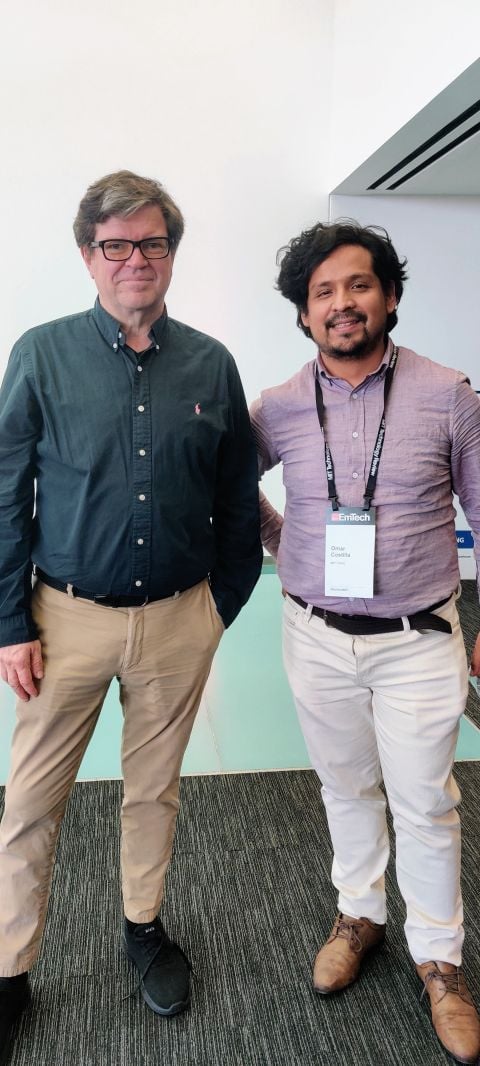 Dr. Omar Costilla Reyes, wearing an EmTech badge, stands beside Yann LeCun at the MIT Media Lab.