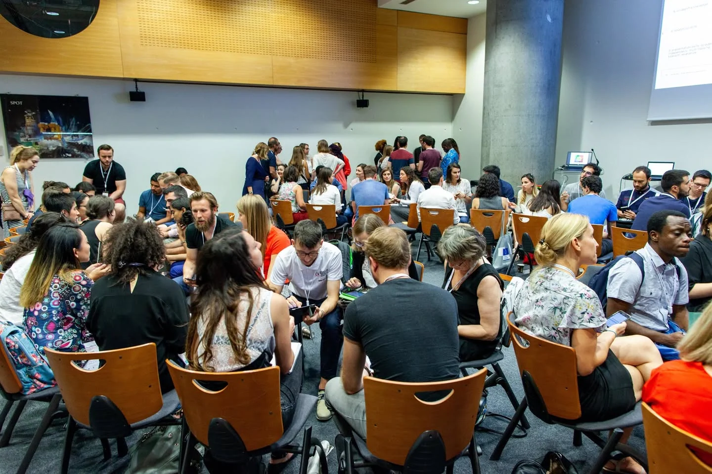 Conference attendees seated around several tables during ESOF 2018 in Toulouse, France.