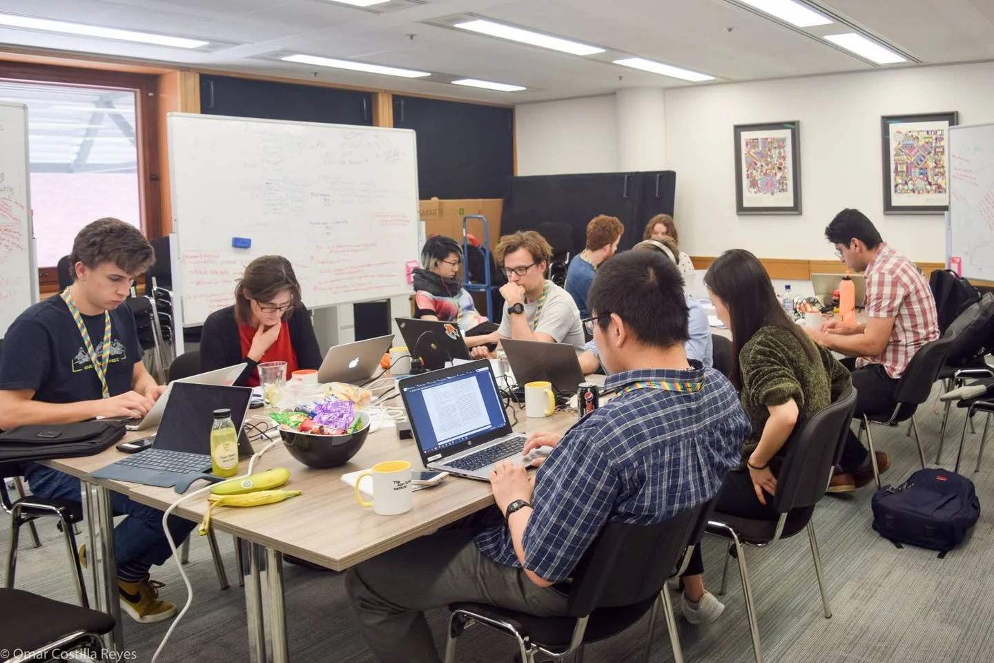 Researchers work together at a table during a Fairness in AI group meeting in London.