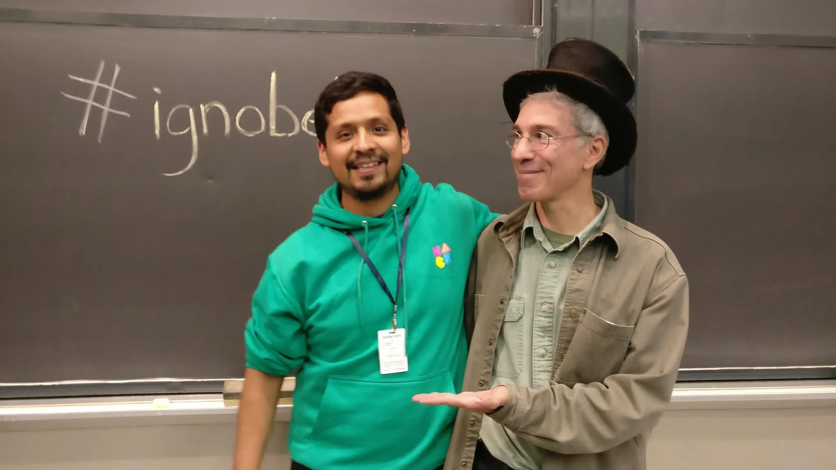 Dr. Omar Costilla Reyes with Marc Abrahams, founder of the Ig Nobel Prize ceremony and editor of the Annals of Improbable Research, beside an Ig Nobel chalkboard in 2019.