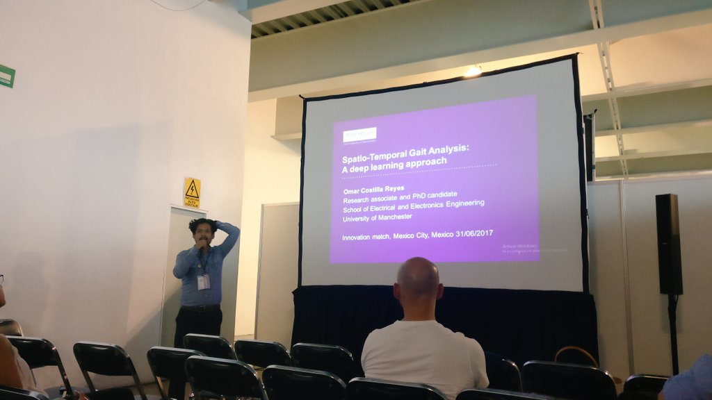 Dr. Omar Costilla Reyes presenting at Innovation Match MX in Mexico City, with an attendee listening in the foreground.