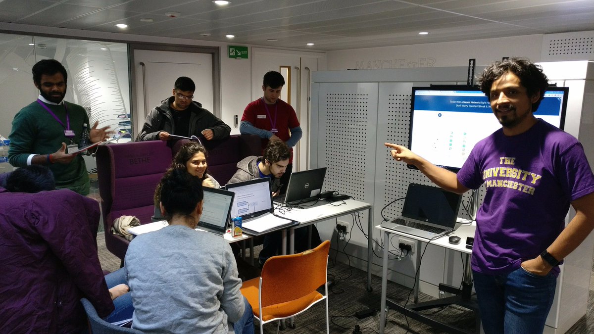 Dr. Omar Costilla Reyes demonstrates a machine-learning activity while workshop participants work together at laptops.