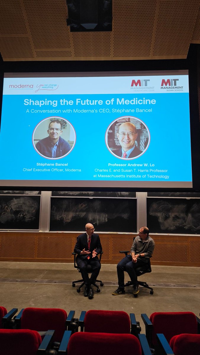 Stéphane Bancel and Andrew Lo speaking together onstage during an MIT conversation about the future of medicine.