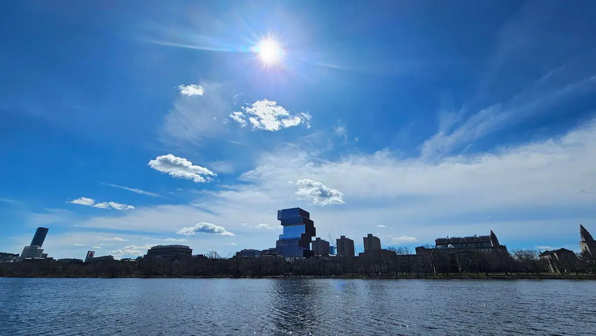 The Charles River and Boston skyline beneath a wide afternoon sky.