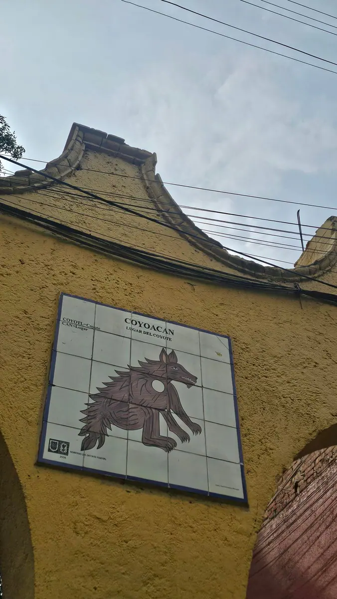 A tiled Coyoacán sign showing the neighborhood’s coyote emblem.