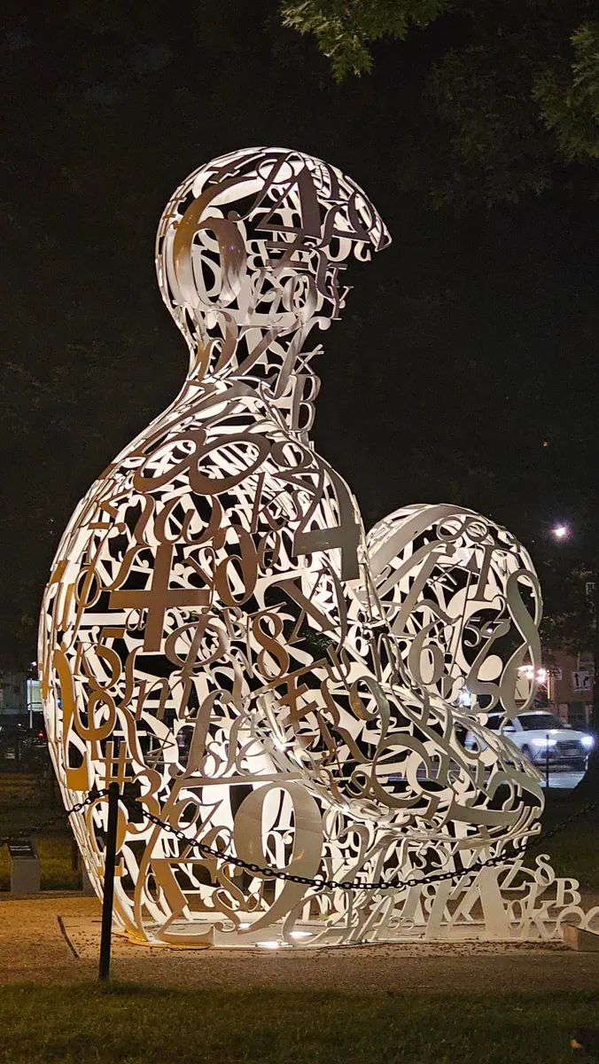 A letter-covered sculpture seen at night during an MIT-area run.