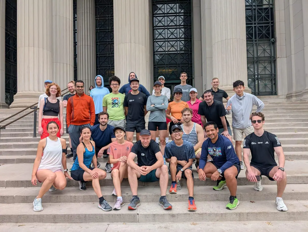 The MIT Postdoctoral Association running group gathers on campus steps.