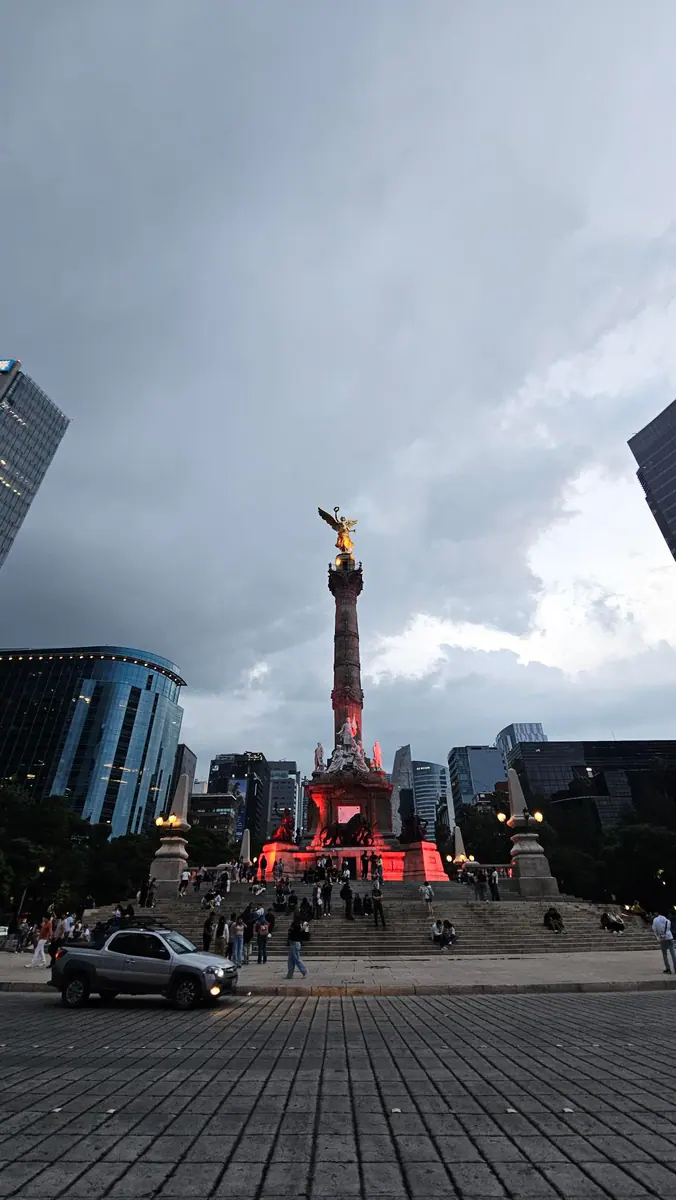 The Angel of Independence monument rises over Paseo de la Reforma at dusk.