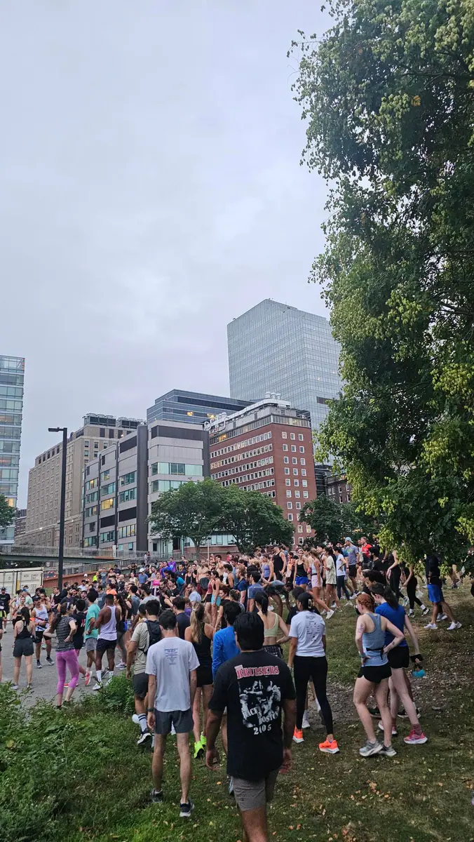 Runners gather outdoors for a Tracksmith Boston community run.